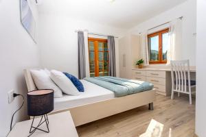 a bedroom with a bed with a desk and a chair at VILLA SKURA private heated pool 32m2, summer kitchen, 4 bedrooms, garden in Duće +42 photos
