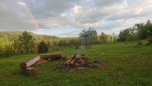 a fire pit in a field with a rainbow in the sky at Domek Na Polanie in Budzów +3 photos