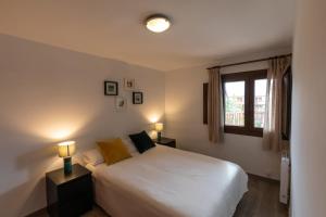 a bedroom with a white bed and a window at Anayet - Plaza del Reloj en FORMIGAL - Reformado in Formigal