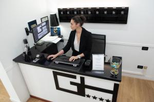 a woman sitting at a desk with a computer at Villa Alba Boutique Hotel in Pescara