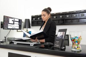a woman sitting at a desk with a laptop at Villa Alba Boutique Hotel in Pescara