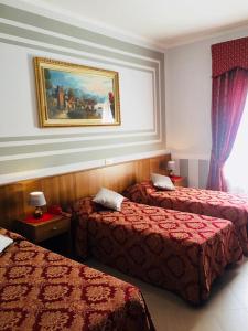 um quarto de hotel com duas camas e um quadro na parede em Hotel Facioni em Pomezia