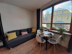 a living room with a couch and a table at Apartmány AMADE Jeseníky in Vrbno pod Pradědem