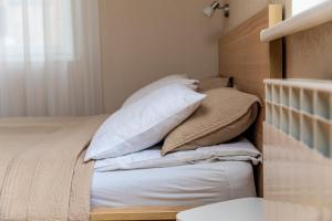 a bed with white pillows on top of it at Palangos Vila in Palanga