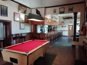 einen Billardtisch in einem Zimmer mit Bar in der Unterkunft Baron's Palace in Oudtshoorn