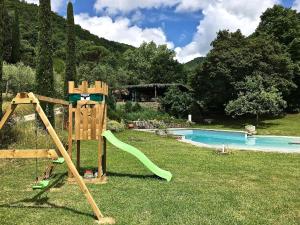 um parque infantil com um escorrega junto a uma piscina em Agriturismo Fattoria Celle em Figline Valdarno