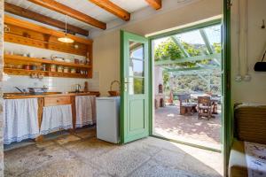 a kitchen with a green door leading to a patio at Holiday home Oliva in Sveti Jakov