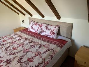 a bed with red and white sheets and pillows at Lovcen Holiday Home in Cetinje