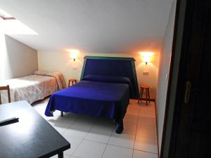 a small bedroom with two beds and a table at Hotel Viar in Cabezón de la Sal