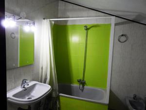 baño verde con lavabo y ducha en Hotel Viar en Cabezón de la Sal