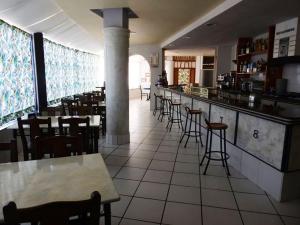 a restaurant with a bar and tables and chairs at Hotel Viar in Cabezón de la Sal