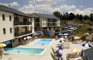 um hotel com piscina e estacionamento em Charmant studio face aux Pyrénées em Font Romeu Odeillo Via