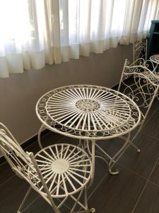a room with a table, chairs, and a clock at Hotel Lukas in Viareggio