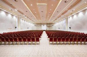 un auditorium vuoto con sedie rosse e un palco di Euphoria Hotel Batumi a Batumi Altre 115 foto