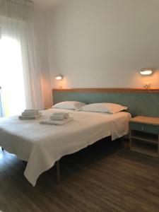 una camera da letto con un grande letto con asciugamani di Hotel Artide a Rimini