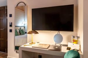 a bedroom with a desk with a tv and a bed at Hotel Claude Marbella in Marbella
