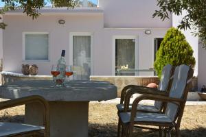 een tafel met twee glazen wijn en twee stoelen bij Sklipi Home in Ermoupoli
