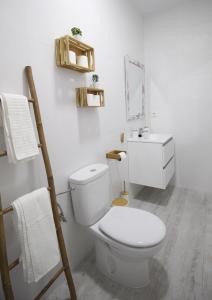 Baño blanco con aseo y lavamanos en Estudio céntrico, en Conil de la Frontera