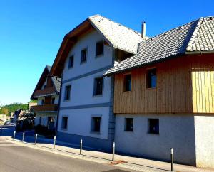 un edificio blanco con techo de madera en una calle en Apartments Janko, en Bled