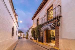 une rue vide avec un bâtiment doté d'un restaurant dans l'établissement Hotel Claude Marbella, à Marbella