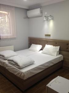 a bed with white sheets and pillows in a room at seasidehouse in Ordu