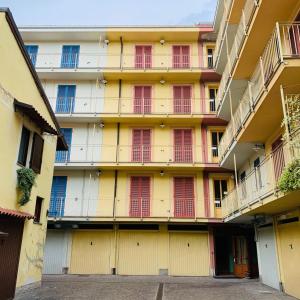 ein gelbes Gebäude mit roten Türen und Balkonen in der Unterkunft Residence Corso Monferrato in Alessandria