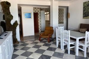 sala de estar con suelo a cuadros, mesa y sillas en Mirador Playa Caleta Cádiz Centro Grupo AC Gestion, en Cádiz