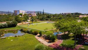 an aerial view of a park with a pond at Quinta dos Poetas Nature Hotel & Apartments in Olhão