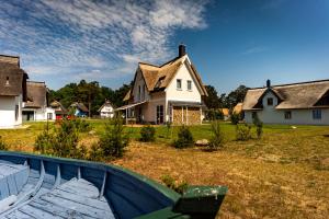 a house with a boat in front of a yard at Luxusferienhaus Fuchsbau - mit Netflix, PlayStation, Sauna, Sportraum und Kamin in Zirchow