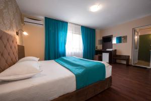 1 dormitorio con 1 cama grande y cortinas azules en Vila Levent Mangalia en Mangalia