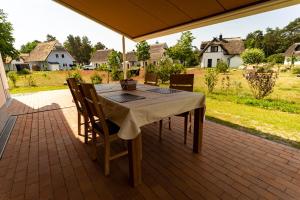 une table et des chaises assises sur une terrasse dans l'établissement Luxusferienhaus Fuchsbau - mit Netflix, PlayStation, Sauna, Sportraum und Kamin, à Zirchow