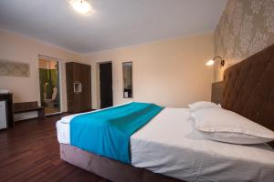 1 dormitorio con 1 cama grande con manta azul en Vila Levent Mangalia en Mangalia