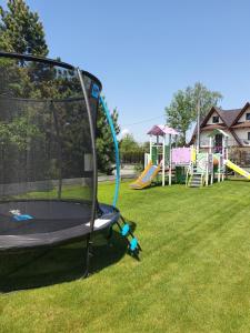 a playground with a trampoline in the grass at Hotel Carlina in Białka Tatrzańska