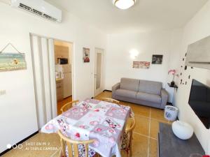 ein kleines Wohnzimmer mit einem Tisch und einem Sofa in der Unterkunft Casa di Teo in Rapallo