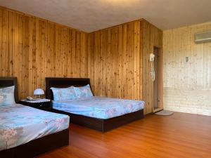 古坑鄉的住宿－華億民宿，一间卧室设有两张床和木镶板墙