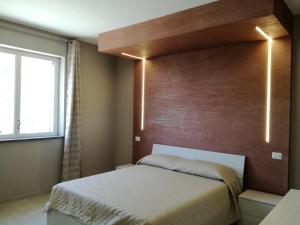 a bedroom with a bed with a wooden headboard at Il Limoneto di Leo in Mascali