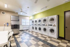 a laundry room with four washer and dryer machines at Studio 6 Bay City TX in Bay City