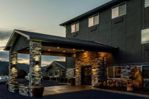 a large building with a stone fireplace in front of it at La Quinta by Wyndham Grants Pass in Grants Pass