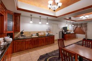 a large kitchen with wooden cabinets and a table at La Quinta by Wyndham Rifle in Rifle