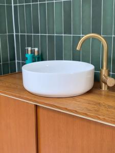 a white sink on top of a wooden counter at The Sunset Apartments in Hollum
