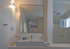 a bathroom with a sink and a mirror at Adonis Hotel Studios & Apartments in Naousa