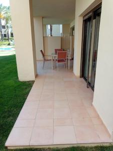 eine Terrasse außerhalb eines Hauses mit einem Tisch und Stühlen in der Unterkunft Bevs ground floor Roda Golf Apartment! in San Javier