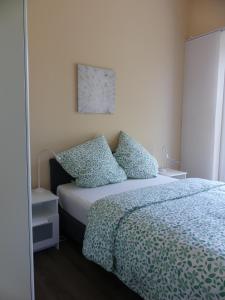 - une chambre avec un lit doté d'une couette et d'oreillers bleus dans l'établissement Townhouse Kassel City Modern/Ruhig/Kostenlose Parkmöglichkeiten, à Cassel