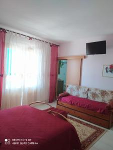 格羅塔列的住宿－B&B Lo Smeraldo，一间卧室配有一张床、一张沙发和一台电视。