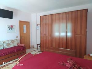 a bedroom with a large wooden cabinet next to a bed at B&B Lo Smeraldo in Grottaglie
