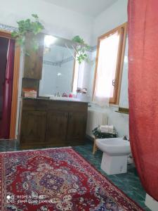a bathroom with a sink and a toilet and a rug at B&B Lo Smeraldo in Grottaglie