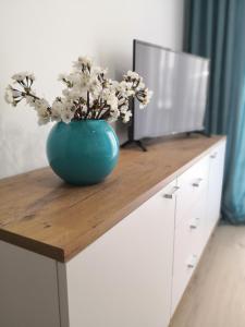 un vase bleu avec des fleurs au-dessus d'une table dans l'établissement Apartament LUCKY, à Świnoujście