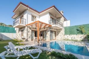 a villa with a swimming pool and a house at Vintage Villas in Kuşadası