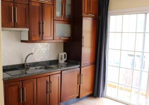 a kitchen with wooden cabinets and a sink and a window at Studio Anna - Valle Gran Rey in Valle Gran Rey