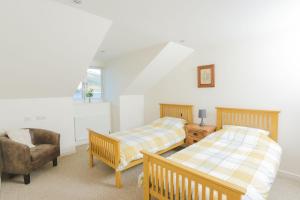 una camera con due letti e una sedia di Clyde View B&B a Dunoon